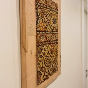 May include: A framed piece of fabric with a colorful floral pattern. The fabric is mounted on a light wood frame.