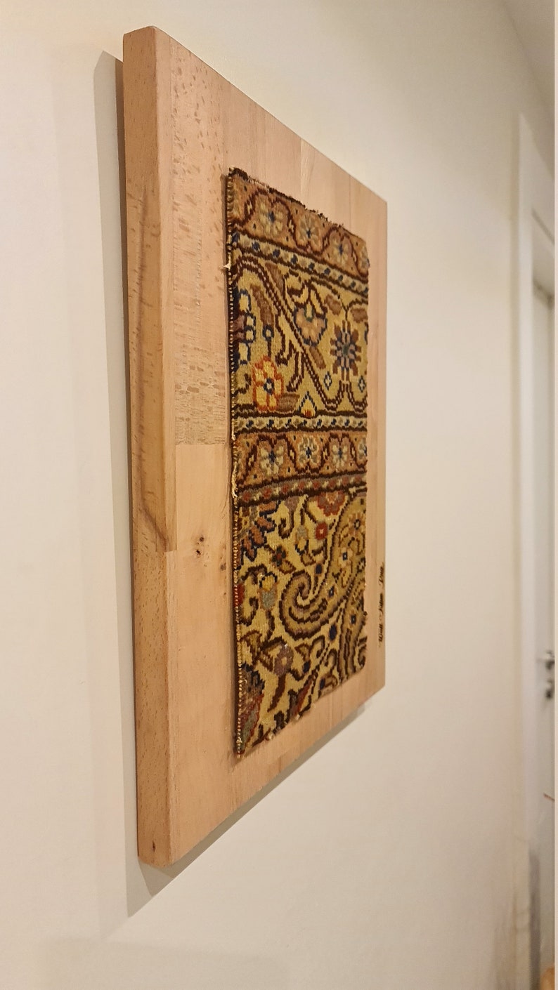 May include: A framed piece of fabric with a colorful floral pattern. The fabric is mounted on a light wood frame.
