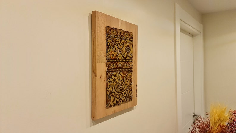 May include: A framed piece of antique fabric with a colorful paisley pattern, mounted on a wooden frame.