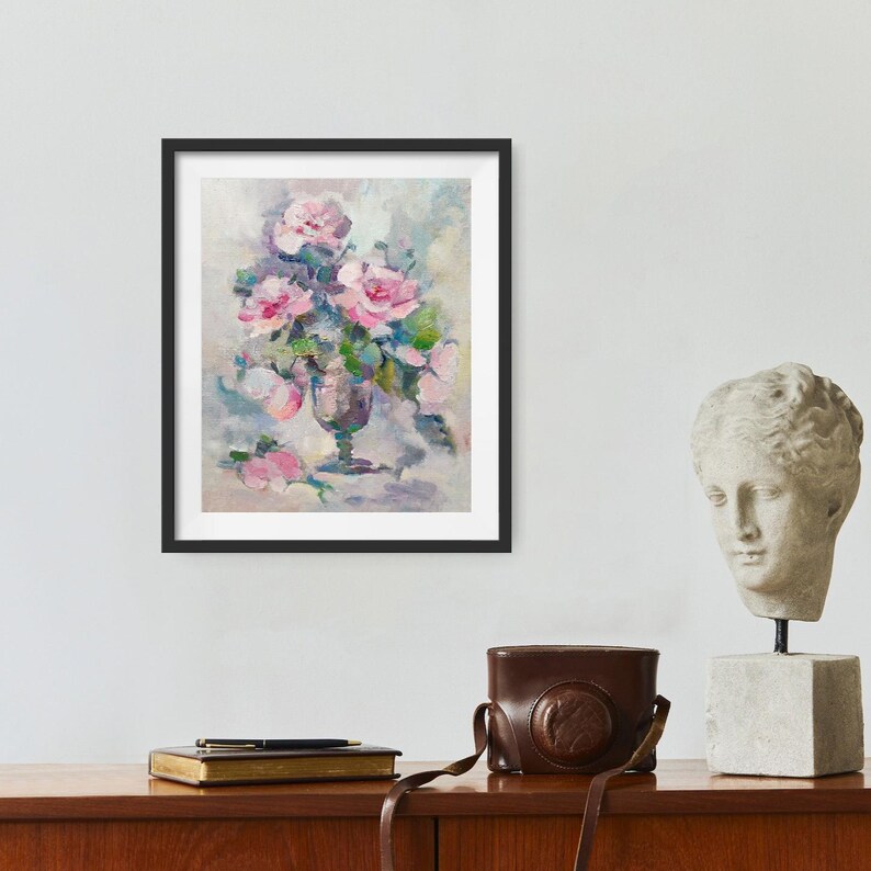 May include: A framed painting of a bouquet of pink roses in a clear glass vase. The roses are arranged in a loose, natural style, and the background is a soft, muted gray.