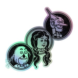 Może przedstawiać: Trzy holograficzne naklejki z postaciami z Czarnoksiężnika z Oz i Pinokia. Naklejki przedstawiają Stracha na Wróble, Dorothy i Pinokia, każdy w czarnym okręgu z efektem tekstury. Naklejki mają tęczowy połysk.