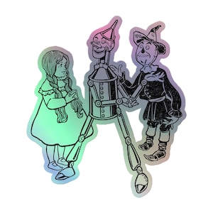 Może przedstawiać: Czarno-biała ilustracja postaci z Czarnoksiężnika z Krainy Oz. Dorotka w sukience, Blaszany Drwal i Strach na Wróble są przedstawieni z efektem holograficznym. Blaszany Drwal jest pośrodku, a Strach na Wróble po jego prawej stronie.