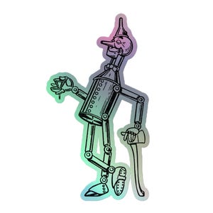 Puede incluir: Una pegatina holográfica del Hombre de Hojalata de El Mago de Oz. La ilustración representa al personaje con un sombrero de embudo, sosteniendo un vaso pequeño y apoyado en un bastón. La pegatina tiene un degradado de colores.