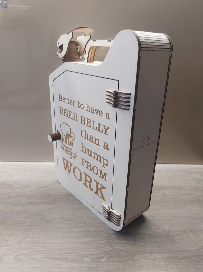Puede incluir: Caja de madera blanca con forma de bid&oacute;n de gasolina con una puerta con bisagras. La caja tiene un recorte de una jarra de cerveza y el texto "Better to have a BEER BELLY than a hump FROM WORK".