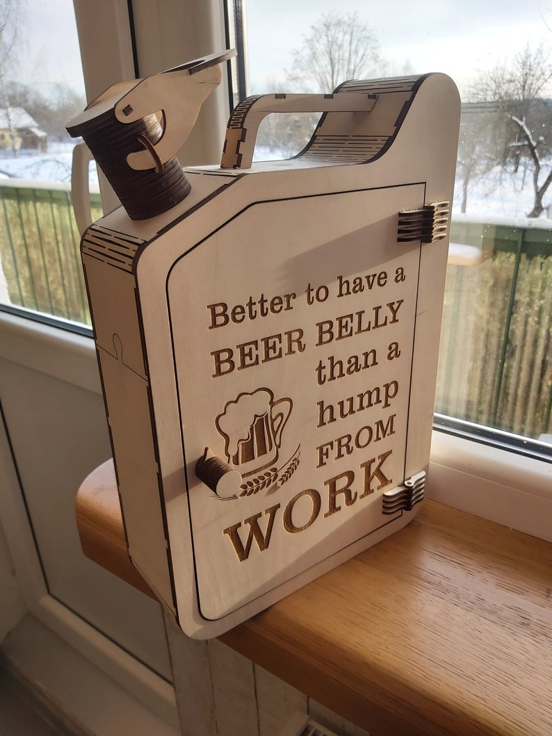 Puede incluir: Caja de madera con forma de bid&oacute;n de gasolina con una puerta con bisagras y un asa. La caja est&aacute; decorada con una jarra de cerveza y el texto "Better to have a BEER BELLY than a hump FROM WORK".