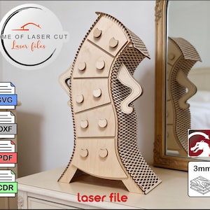 May include: A light-colored wooden laser-cut cabinet with six drawers and decorative side accents. The cabinet has a unique, curved design and is displayed on a white table. The image includes the text "HOME OF LASER CUT Laser files" and "laser file".
