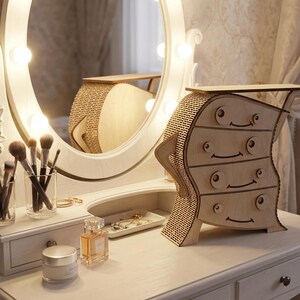 May include: A whimsical wooden dresser with four drawers, featuring a unique, wavy design. The dresser is placed on a white vanity table, next to a lighted vanity mirror and makeup brushes. The overall theme is home decor.