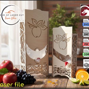 May include: Two light-colored wooden beverage dispensers with laser-cut lattice side panels and an apple illustration on the front. Each dispenser features a plastic spigot and a clear internal bag. The text HOME OF LASER CUT and laser file are visible.