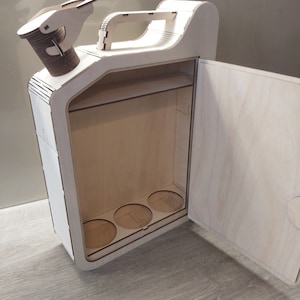 Puede incluir: Una caja de madera con forma de bid&oacute;n de gasolina con una puerta con bisagras y un asa. La caja tiene un estante y cuatro recortes circulares en la parte inferior. La caja est&aacute; hecha de madera clara y tiene un acabado natural.