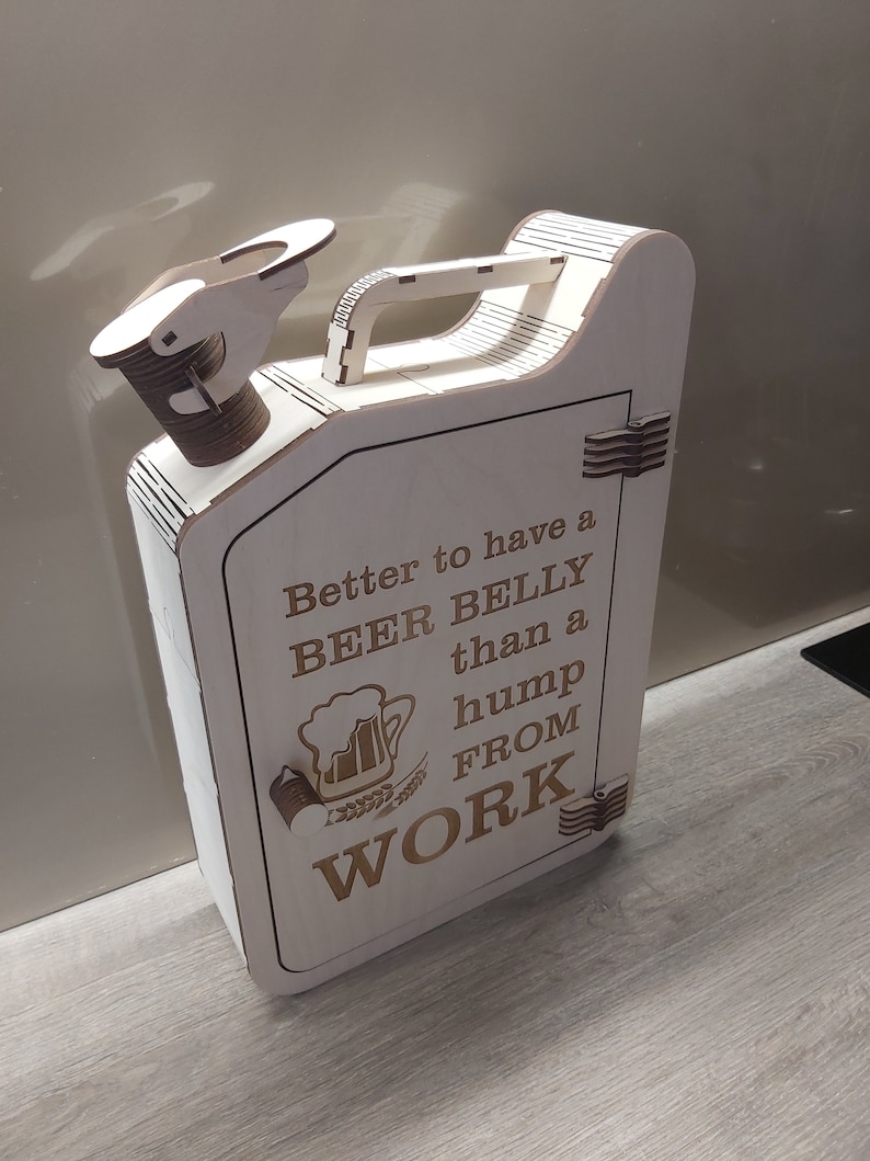 Puede incluir: Una caja de madera con forma de bid&oacute;n de gasolina con una puerta con bisagras y un asa. La caja tiene un dise&ntilde;o grabado con l&aacute;ser de una jarra de cerveza y el texto "Better to have a BEER BELLY than a hump from WORK".