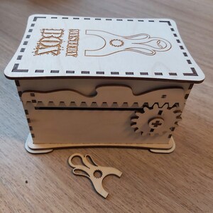 May include: A wooden box with a decorative design and a small gear on the side. The box has a slot on the top and the text "WISHERRY BOX" is engraved on the lid.