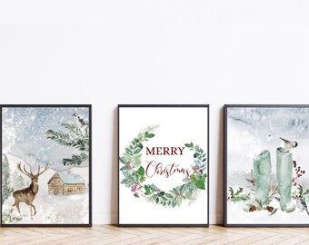 May include: Set of three framed watercolor prints with a winter theme. The prints feature a deer near a cabin, a wreath with "Merry Christmas" text, and two candles with a bird. The frames are black.