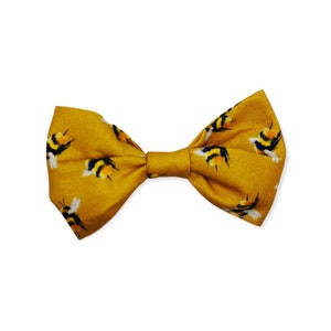 May include: A yellow bow tie with a pattern of black and yellow bumblebees.
