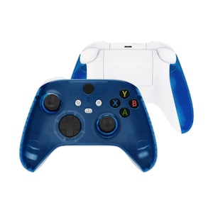 May include: Two wireless game controllers. One controller is in focus, showing a dark blue front with black joysticks and buttons. The other controller is behind it, showing a white back with blue accents. The controllers have the standard button layout.