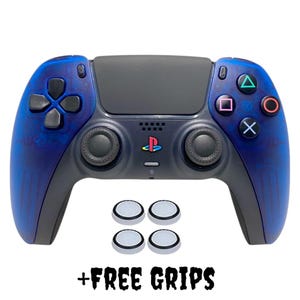 May include: A blue and black PlayStation 5 controller with four white thumb grips. The controller has a PlayStation logo on the front and a blue and black swirl pattern on the back. + FREE GRIPS