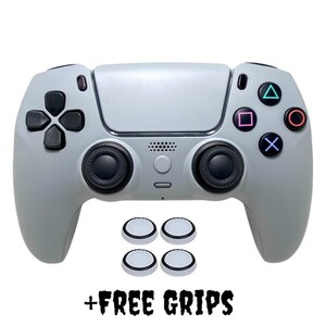 May include: A gray PlayStation 5 controller with black buttons and analog sticks. Four white thumb grips are included. + FREE GRIPS