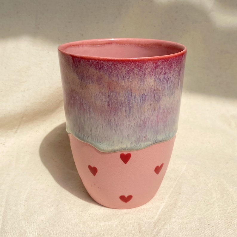 pink porcelain mug on the top flowing glaze and under red hearts