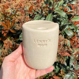 Puede incluir: Un juego de tres tazas de cerámica con un acabado moteado y mate. Las tazas son de color crema, gris claro y gris oscuro. Cada taza tiene un diseño simple y minimalista y un asa redondeada.