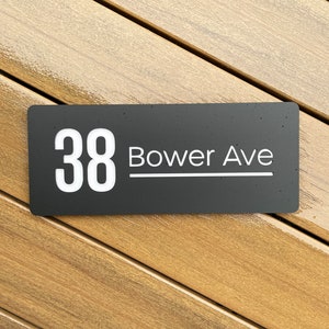 May include: Black house number sign with white lettering. The number 38 and the street name "Bower Ave" are displayed on the sign.