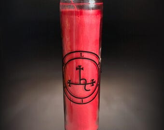 May include: A tall, cylindrical clear glass candle holder filled with solid red wax. A black circular emblem is printed on the front, featuring a central cross-like sigil surrounded by the letters L, I, L, I, T, H arranged in a circle.