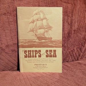 May include: A vintage catalog titled "SHIPS & SEA" featuring a sepia-toned illustration of a sailing ship on the cover. The catalog lists marine prints, ship models, and nautical items. The catalog is from Preston's at Main Street Wharf, Greenport, Long Island, N.Y.