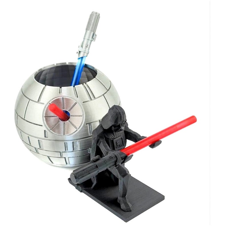 May include: A silver Death Star-shaped desk organizer with a black Darth Vader figurine holding a red lightsaber. The Death Star organizer has a blue lightsaber inside.