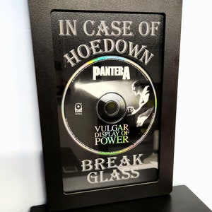 May include: A black framed box with a CD inside. The CD is a Pantera album titled "Vulgar Display of Power". The text "In Case of Hoedown Break Glass" is printed on the frame.