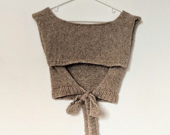 May include: A brown knitted sleeveless top with a tie at the back.