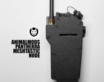Puede incluir: Un dispositivo electrónico negro y rectangular con una antena negra y un botón negro y redondo. El dispositivo tiene varios tornillos y una ranura en la parte delantera. El texto "ANIMALMODS PANTHERRA MESHTASTIC NODE" está impreso en el lado izquierdo, junto con un logotipo.