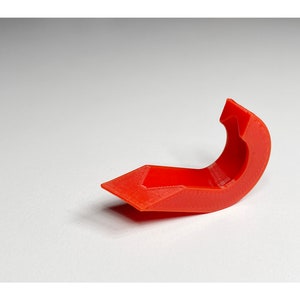 May include: A bright red plastic 3D printed hook with a curved shape.