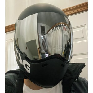 Pu&ograve; includere: Casco da moto nero con visiera trasparente e la scritta "ESG" stampata sul lato.