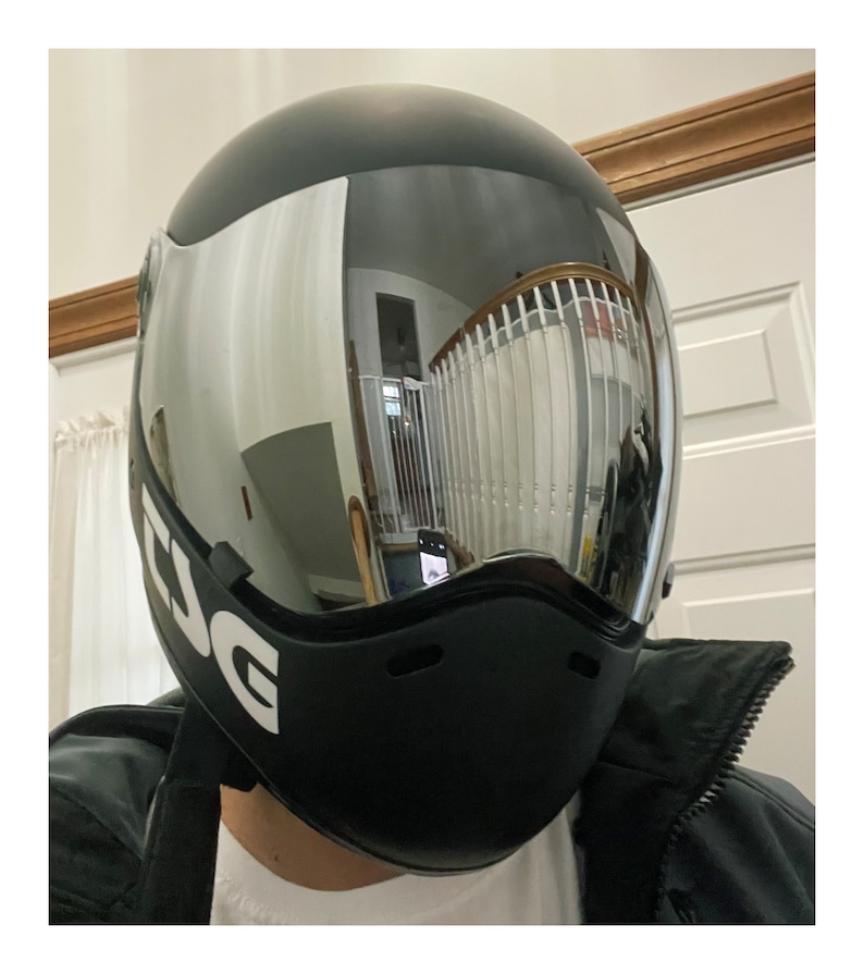 Pu&ograve; includere: Casco da moto nero con visiera trasparente e la scritta "ESG" stampata sul lato.