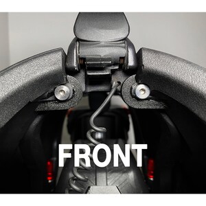 May include: Close-up of a black camera case with a hinge and two silver screws. The case is open and the word "FRONT" is visible in white letters.