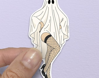 May include: A white ghost sticker with black eyes and a sheet draped over the body. The ghost is wearing a black garter belt, fishnet stockings, and black high heels. The sticker is held by a hand.