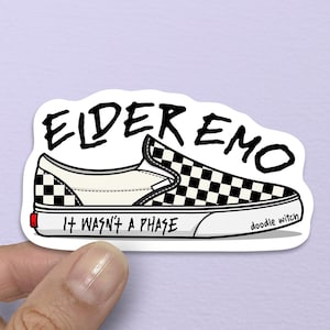 May include: A sticker featuring a black and white checkered slip-on shoe design. The text "ELDER EMO" is above the shoe, with "IT WASN'T A PHASE" below. The artist's signature, "doodle witch," is on the side.