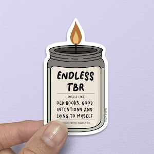 Könnte beinhalten: Ein Aufkleber in Form eines Kerzenglases mit dem Text "ENDLESS TBR" und dem Satz "- SMELLS LIKE - OLD BOOKS, GOOD INTENTIONS AND LYING TO MYSELF." Die Kerze hat einen grauen Deckel und eine gelbe Flamme.