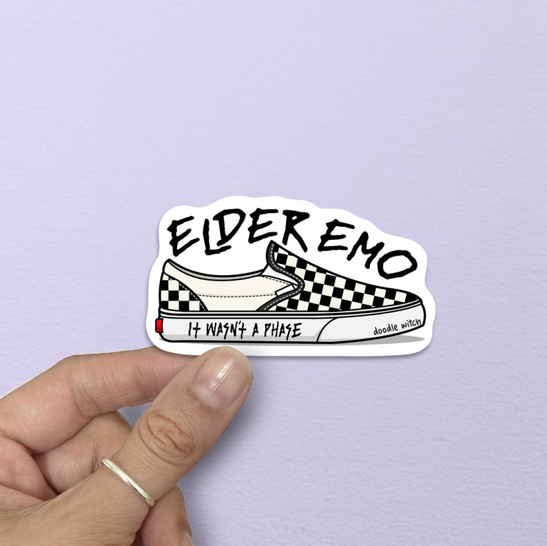 May include: A sticker featuring a black and white checkered slip-on shoe design. The text "ELDER EMO" is above the shoe, with "IT WASN'T A PHASE" below. The artist's signature, "doodle witch," is on the side.