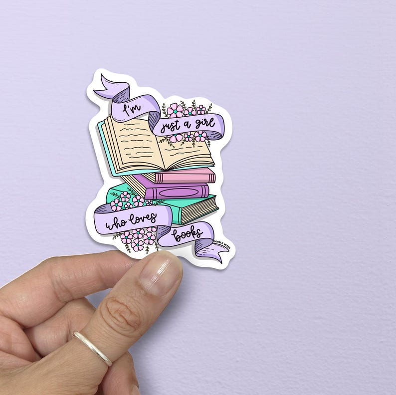 May include: A sticker featuring a stack of books with a banner that reads "I'm just a girl who loves books." The books are in shades of green, pink, and purple. The banner is light purple with floral accents.