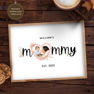 Könnte beinhalten: Ein weißes, bedruckbares Schild mit einem rosa Herzen und den Worten "Mommy" in schwarzer Schrift. Das Herz enthält ein Foto eines Babys und einer Frau. Der Text "William's" und "Est. 2023" befindet sich ebenfalls auf dem Schild.
