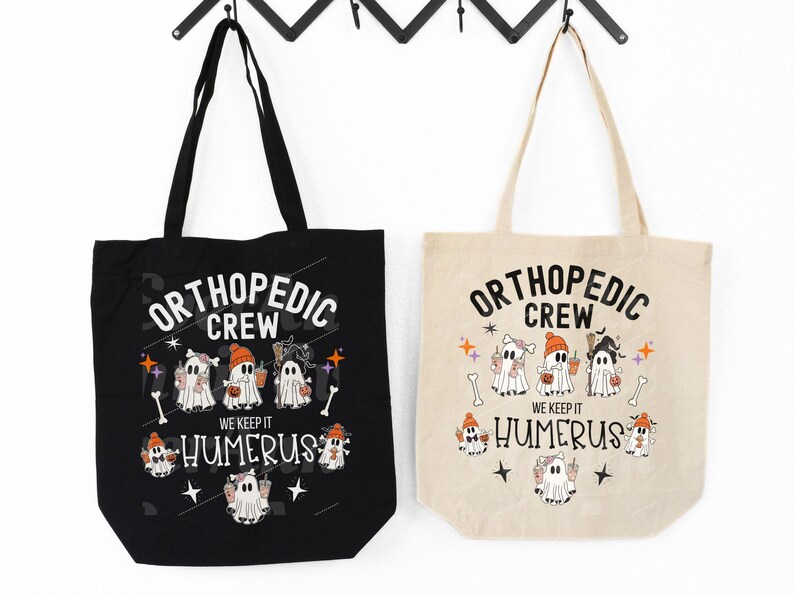 May include: Two black and beige tote bags with a Halloween theme. The bags feature a graphic of ghosts with the text "Orthopedic Crew" and "We Keep It Humerus".