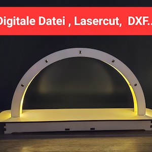 May include: White wooden arch with a base, lit from within with warm white lights. The arch is designed for a Christmas village or other holiday display.  The text "Digitale Datei, Lasercut, DXF..." is visible at the top of the image.