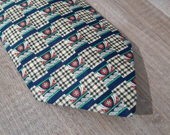 May include: A patterned tie with a blue, green, white, and red design. The tie has a checkered pattern with a floral design.