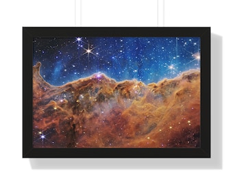 May include: A framed photograph of a nebula in space. The nebula is a swirling mass of gas and dust, with a bright blue and orange color scheme. The nebula is surrounded by a field of stars.