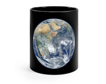 May include: A black ceramic mug with a full-color image of planet Earth on the front. The Earth is shown with continents and oceans, and clouds are visible.