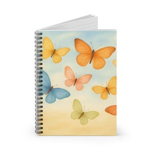 May include: Spiral-bound notebook with a watercolour design of butterflies in yellow, orange, pink, blue, and green against a sky-themed background. The notebook has a white spiral binding and blank pages.