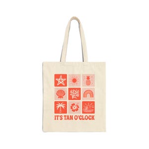 May include: Cream-colored tote bag with a repeating coral and pink square pattern of beach-themed icons. The icons include a starfish, sun, pineapple, seashell, coral, rainbow, palm tree, hibiscus flower, and a sunset. The text "IT'S TAN O'CLOCK" is printed at the bottom.