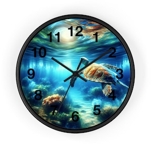 May include: Round wall clock with a black frame featuring a vibrant underwater scene. A sea turtle swims in a blue ocean with coral and sunlight. The clock hands are black, and the numbers are in a classic font.