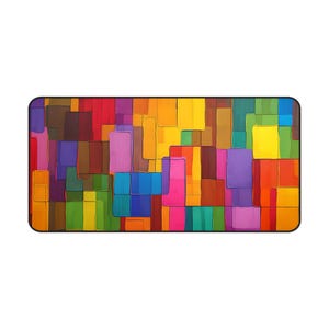 May include: Rectangular mousepad with a vibrant abstract design. The artwork features a mosaic of colorful, irregular rectangles in shades of red, yellow, purple, green, and blue. The mousepad has a black border.