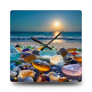 May include: Square wall clock featuring a beach scene with colorful sea glass and a sunset over the ocean. The clock hands are black, and the clock face is filled with various colors of sea glass. The clock is a decorative item.
