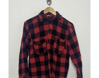 May include: A red and black plaid flannel shirt with long sleeves and two chest pockets.